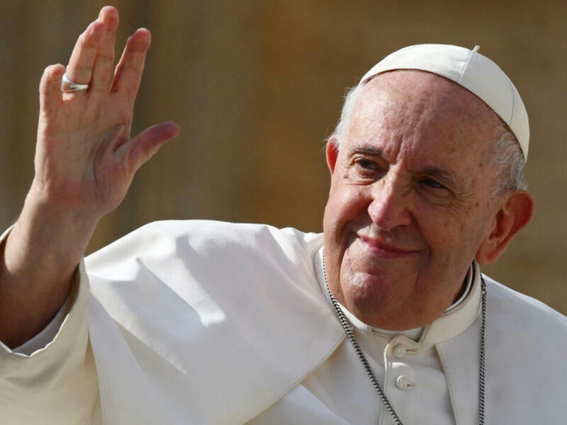 El Papa Francisco saludando con la mano derecha.