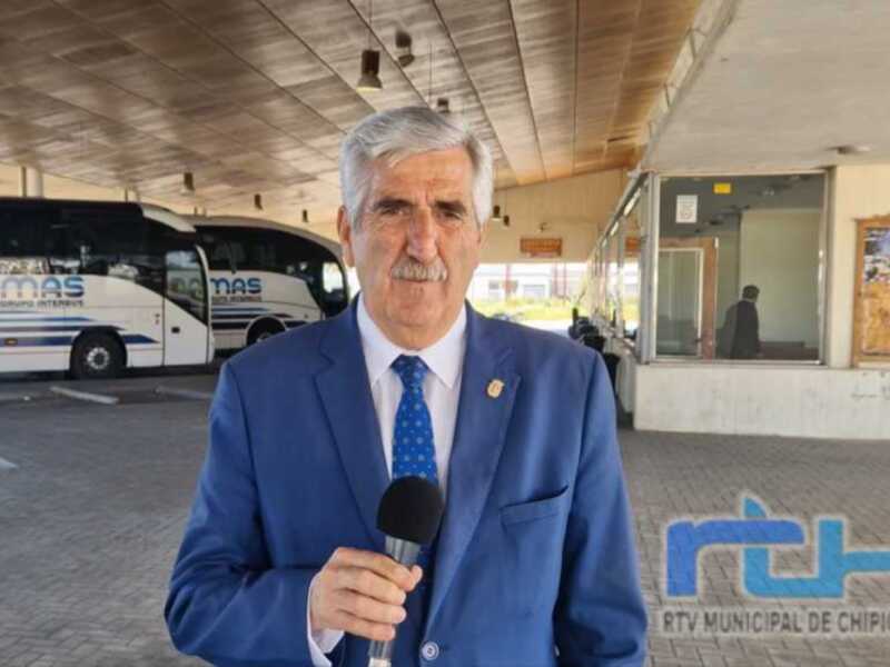 Entrevista en el terminal de autobuses de Chipiona, con el logo de RTV Municipal de Chipiona en el fondo.