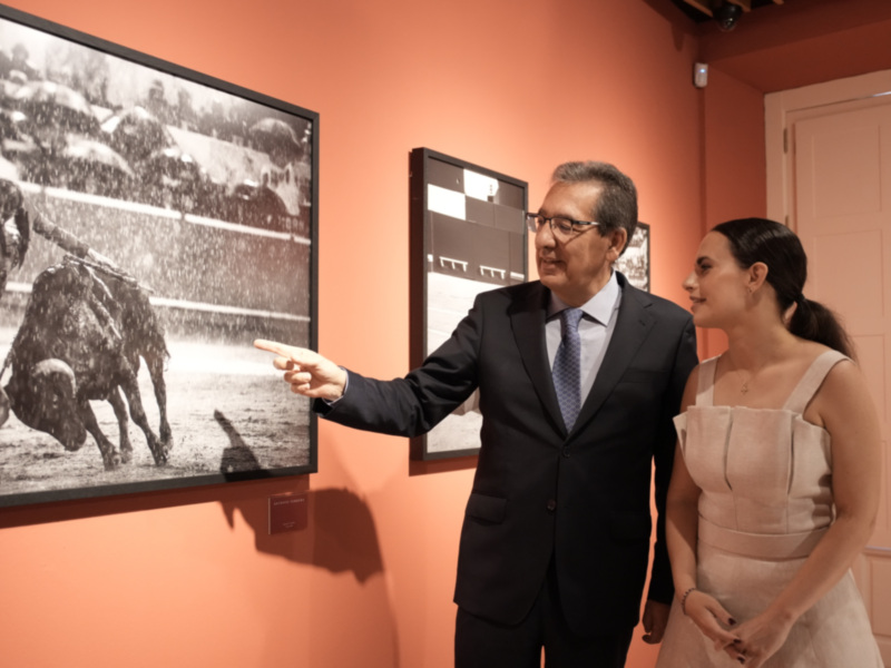 Gente observando una exposición fotográfica en un museo.
