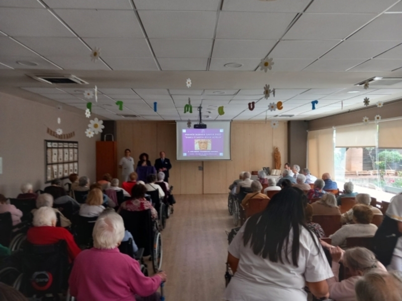 Reunión informativa en un centro de mayores con una presentación sobre la importancia de la actividad física.