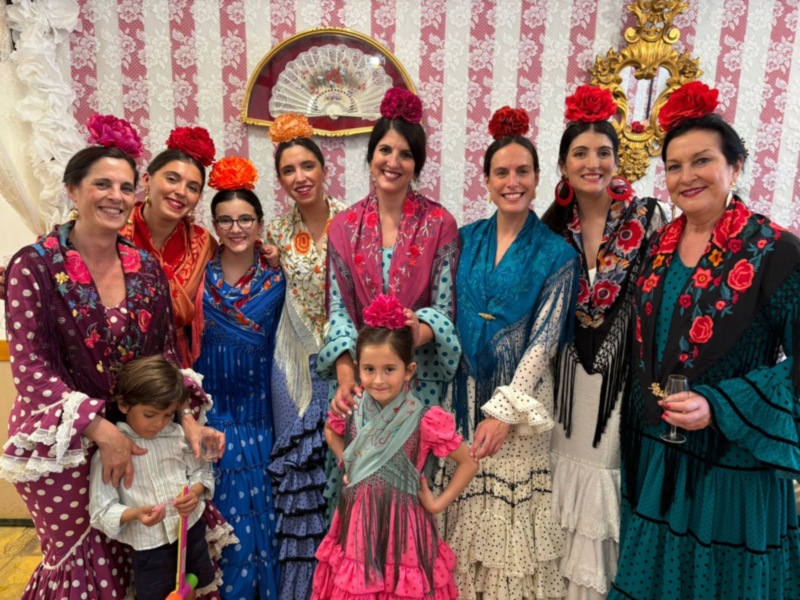 Una familia feliz en trajes tradicionales de flamenco, posando con orgullo.