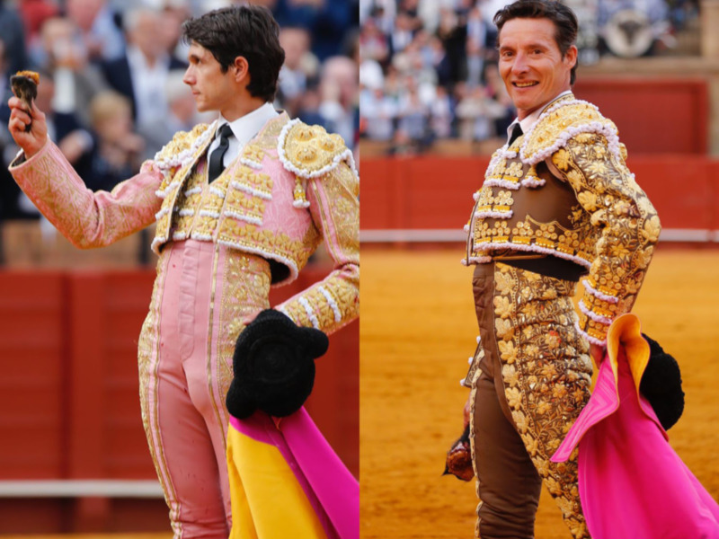 Dos toreros en trajes tradicionales de la tauromaquia, uno con un chaleco rosa y otro con un chaleco marrón, en una corrida de toros en un estadio lleno de espectadores.
