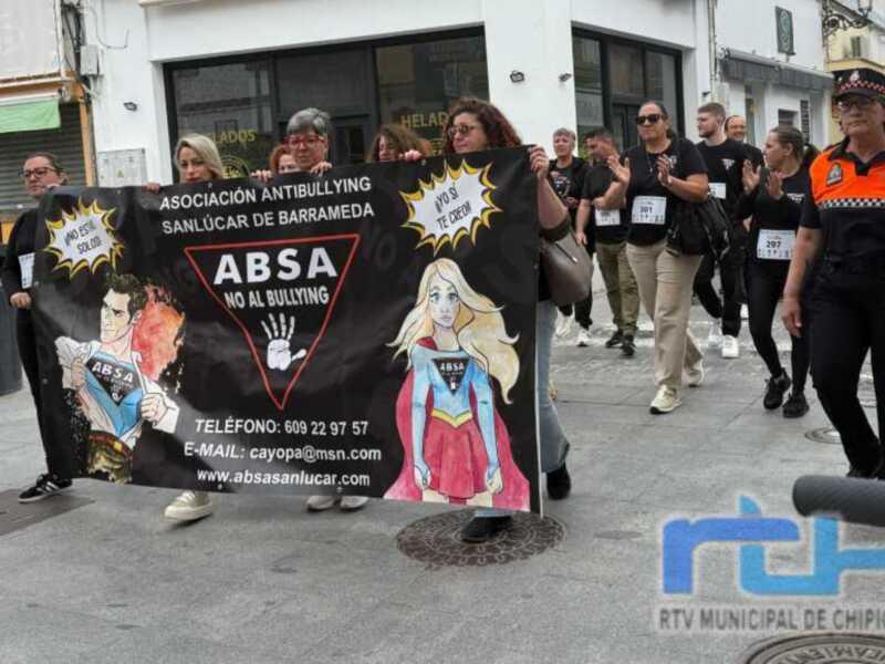 Marcha contra el Bullying en Sanlúcar de Barrameda, con participantes y una pancarta de la Asociación Antibullying.