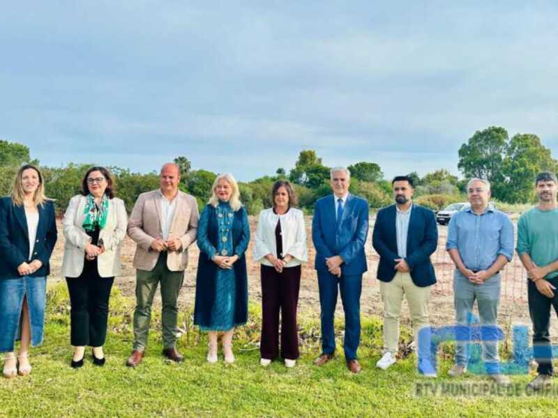 Oficiales y autoridades posan en un evento de inauguración en un terreno verde.