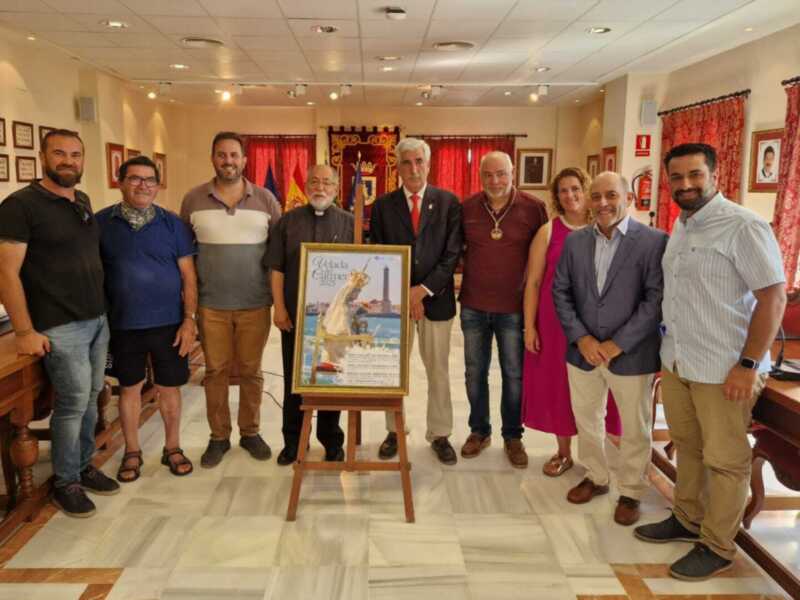 Grupo de personas posando junto a un cartel en un salón de oficinas con decoración de rojo y blanco.