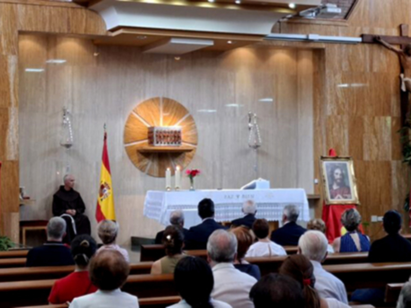 Celebración religiosa en una iglesia con un sacerdote oficiando la misa y fieles asistentes.