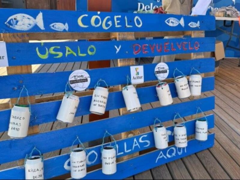 Piedra de foto de una instalación de reciclaje con contenedores de plástico pintados con mensajes de concientización sobre la importancia del reciclaje y la protección del medio ambiente.