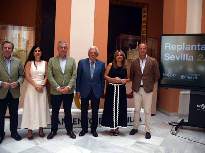 Presentación del proyecto 'Replanta Sevilla 2.0' en un evento formal con participantes vestidos de manera elegante.