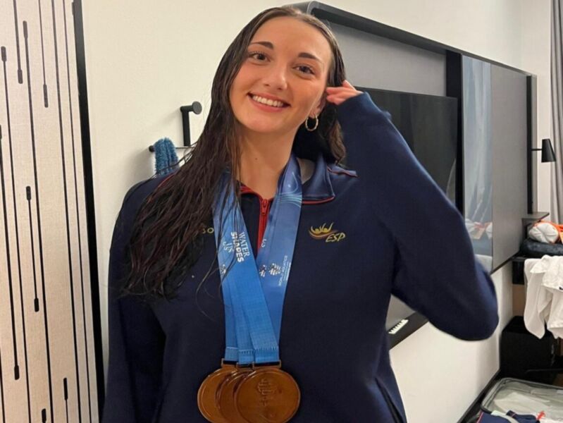 Atleta con medallas de oro, orgullosa de su logro en los Juegos Mundiales de Natación.