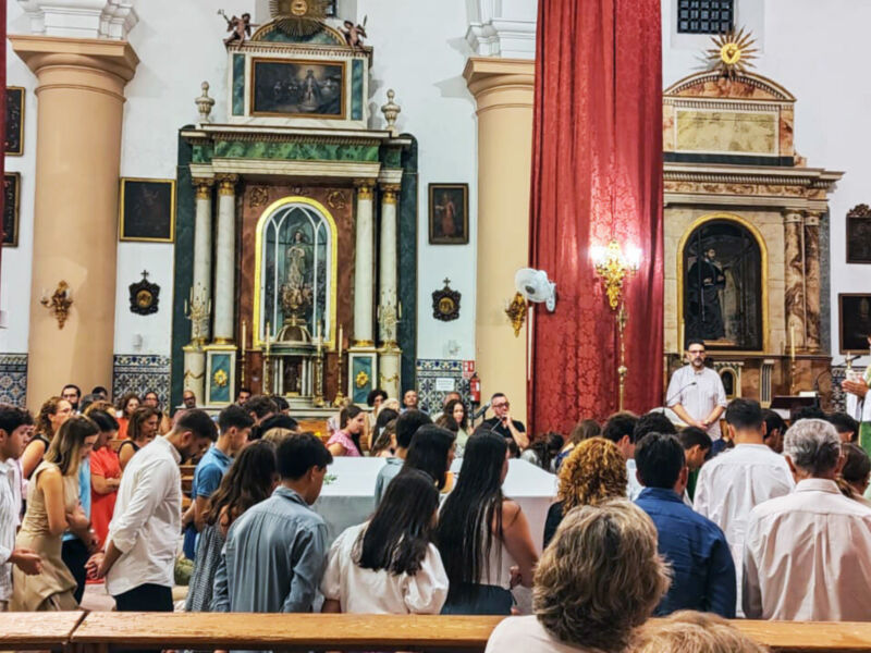 Celebración religiosa en una iglesia con un sacerdote oficiando la misa ante una congregación congregada.