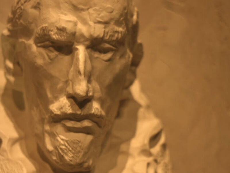 Busto de un personaje histórico en relieve, con detalles expresivos y texturas suaves.