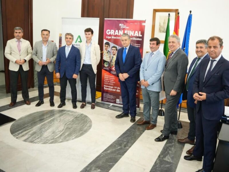 Una imagen de una gran final de competición, con varios hombres en trajes posando frente a dos banners que dicen "Gran Final" y "Liga Nacional de Estudiantes". La escena se realiza en un entorno formal con una alfombra negra y blanca.