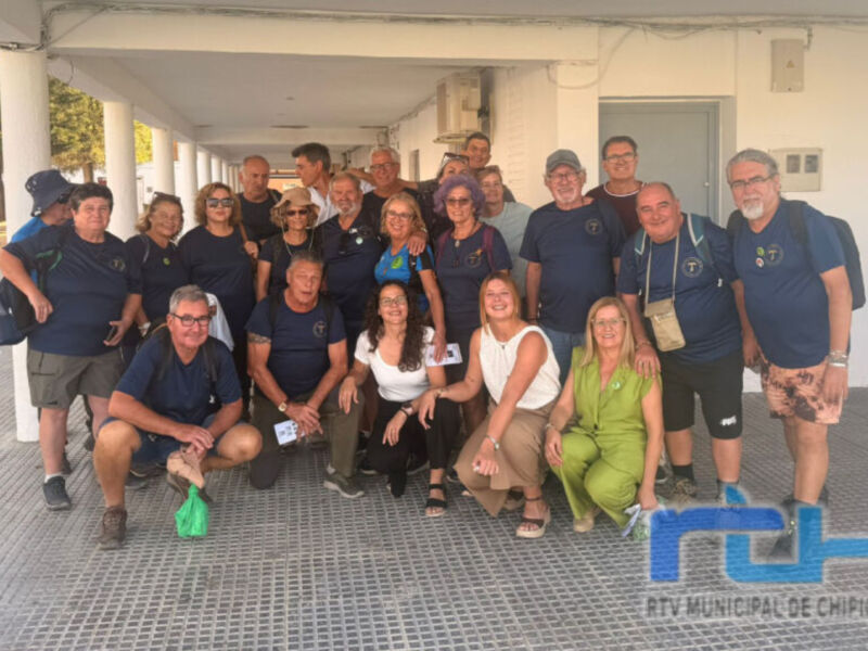 Grupo de personas en una reunión o evento deportivo, posando frente a un edificio.