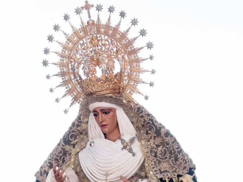 Imagen de la Virgen María con un halo estrellado y vestimenta tradicional, probablemente en una celebración religiosa.