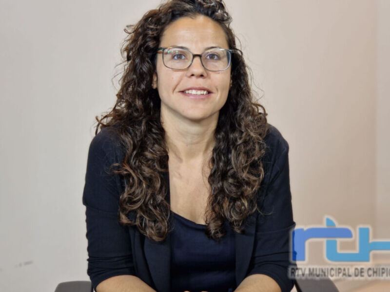 A una mujer con cabello ondulado y gafas, sonriendo frente a un fondo claro. La imagen está acompañada por el logo de RTV Municipal de Chipiona en la esquina inferior derecha.
