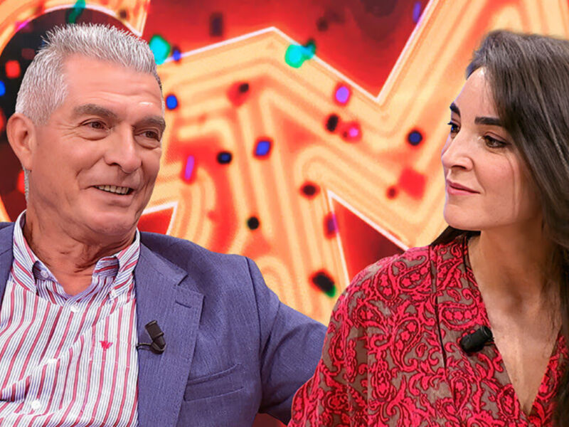 Dos personas conversan frente a un fondo con luces de colores. La imagen parece ser de una entrevista o programa de televisión.