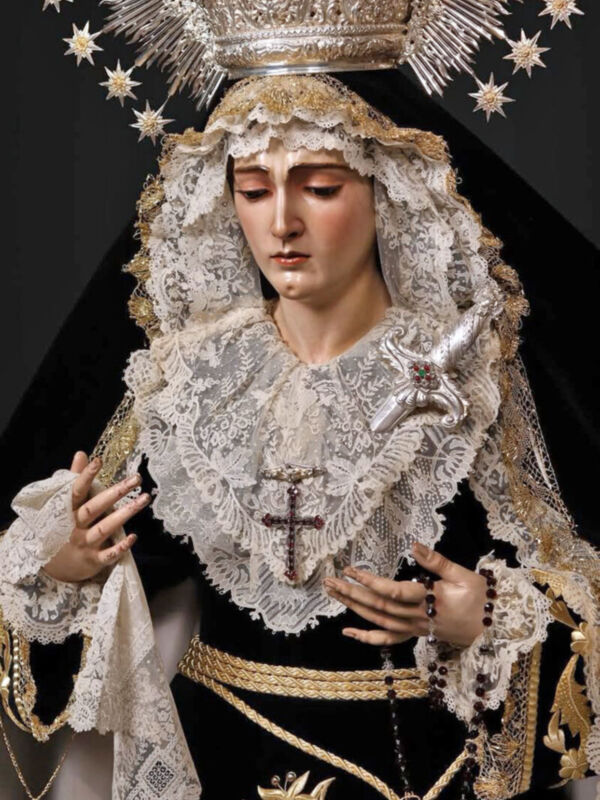 Virgen María con vestimenta tradicional y un cetro en la mano izquierda.