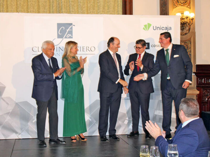 Una celebración formal con cuatro personas en trajes y una mujer en un vestido verde, posando frente a un fondo con logos de CFA y Unicaja.