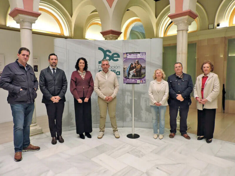 Grupo de personas posando frente a un panel con el logotipo de JSE en una sala con arcos y columnas.